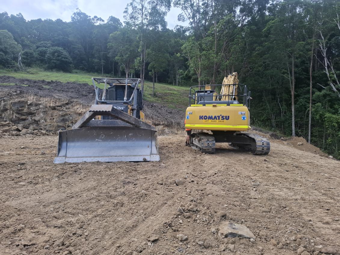 Dozer and Komatsu excavator parked on a finished rock and clay building pad in the Tweed Valley NSW