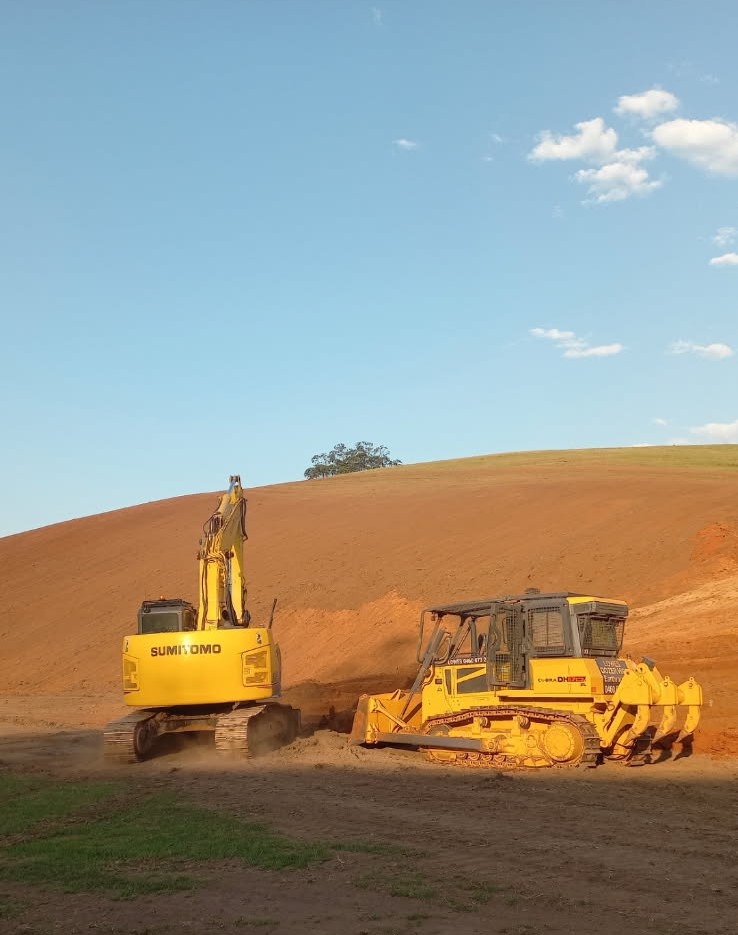 Sumitomo excavator and Lowes dozer shaping a large red-soil cut on a hillside near Murwillumbah, Northern Rivers NSW