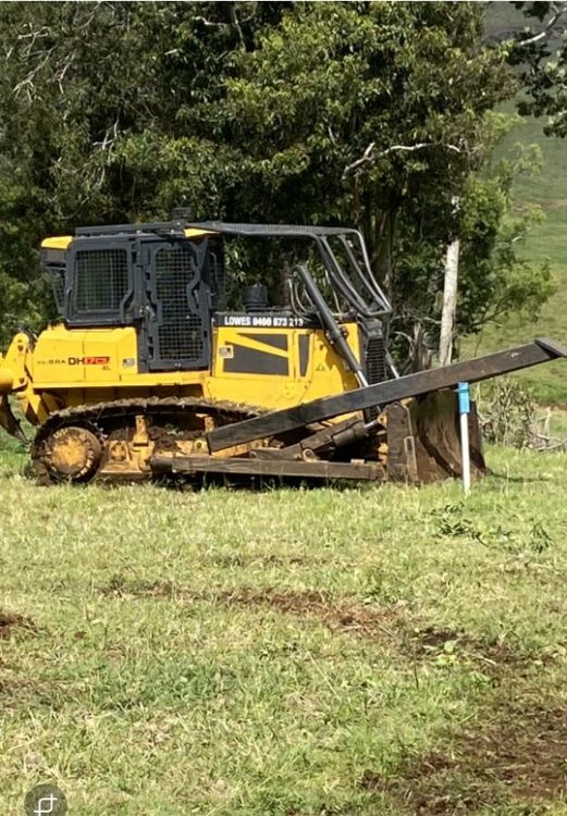Lowes Earthmoving dozer with stick rake attachment working a green paddock in the Northern Rivers NSW